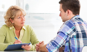 man-talking-to-woman-at-desk